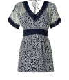 Whimsical navy and white floral-printed dress - V-neck at front and back - Simple tie detail at back - Wide blue trim at collar, sleeves and waist accent - Flowing, transparent sleeves - Bold white trim at hem - Style with wedge sandals for chic day look or pair with a blazer and simple heels to take to the office