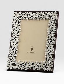 White Swarovski crystals shimmer on the platinum tone floral garland that surrounds this rich leather design.Holds 5 X 7 photoClassic beveled glassStretched leather backingGift boxedImported White Swarovski crystals shimmer on the platinum tone floral garland that surrounds this rich leather design.Holds 5 X 7 photoClassic beveled glassStretched leather backingGift boxedImported