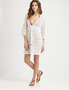 A gorgeous crochet coverup with a feminine self-tie neckline.Deep v-necklineThree-quarter sleevesSelf-tie frontCord endsElasticized waistCottonDry cleanMade in USA of imported fabric