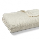 A chunky, soft knit blanket in a neutral hue from DIANE von FURSTENBERG elevates a simple bedding ensemble.