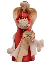 With a flowing red dress and her hand nestled in a muff, this lovely angel figurine delivers warm wishes to your home with the phrase: Christmas Blessings. With crystal embellishments. With a flowing red dress and her hand nestled in a muff, this lovely angel figurine delivers warm wishes to your home with the phrase: Christmas Blessings. With crystal embellishments.